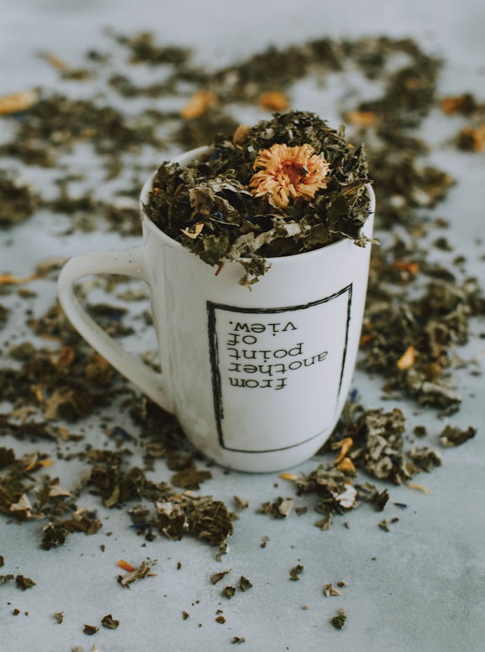pexels-photo-1793034 A close-up of an herbal tea mug filled with dried leaves and flowers on a table.